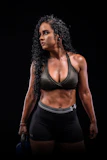 Dynamic shot of a woman lifting weights in sleek black and blue Pulseforge training set inside a gym