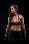 Dynamic shot of a woman lifting weights in sleek black and blue Pulseforge training set inside a gym