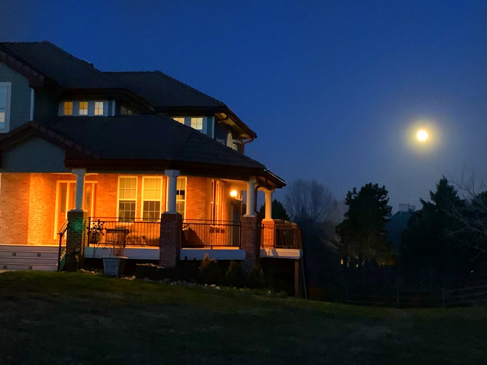 brown and white house near green trees during night time