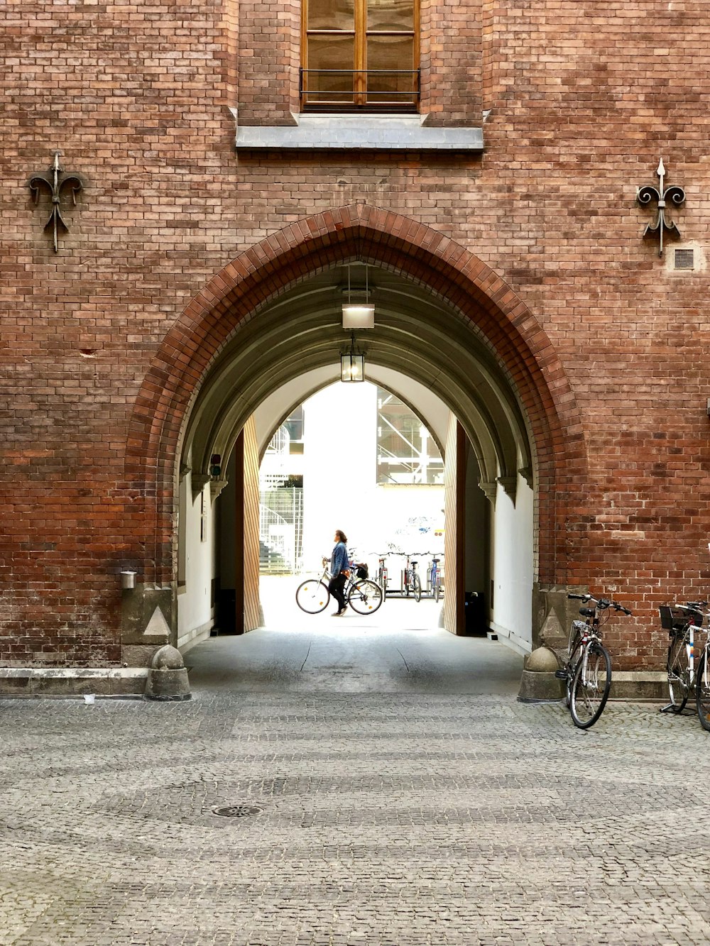 man in black jacket and black pants walking on sidewalk during daytime