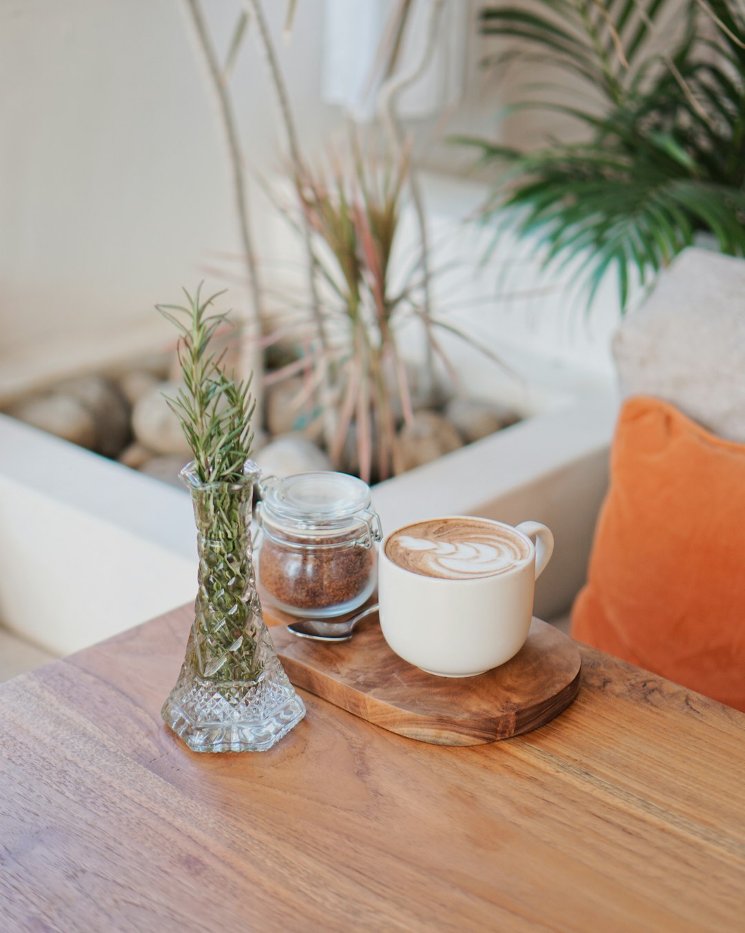 white liquid in clear glass jar beside white ceramic mug on brown wooden table