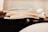 A stack of magazines is placed on a wooden surface. The image focuses on the edges of the pages, giving a sense of the texture and paper quality.