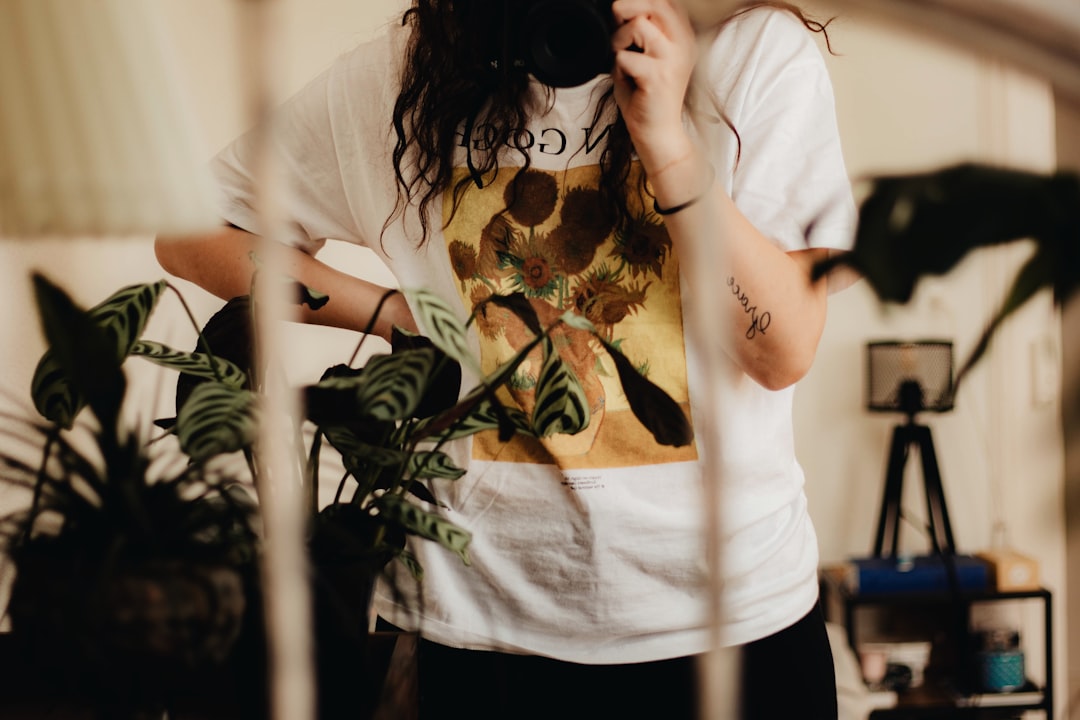 woman in white t-shirt holding green plant