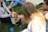 A happy family playing with their corgi puppy in a sunny backyard.