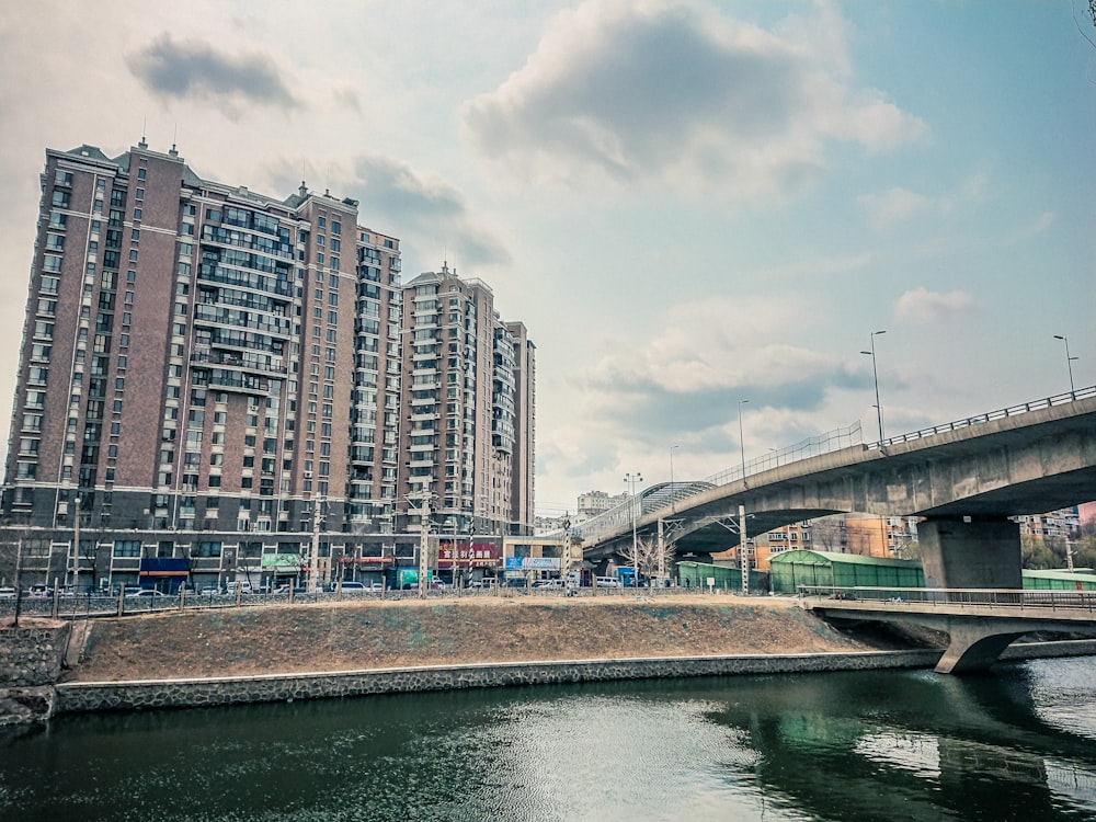 white and brown concrete building near body of water under white clouds during daytime