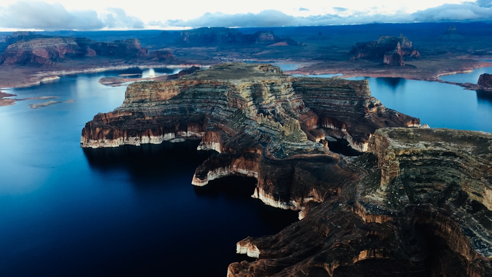 brown rock formation near body of water during daytime