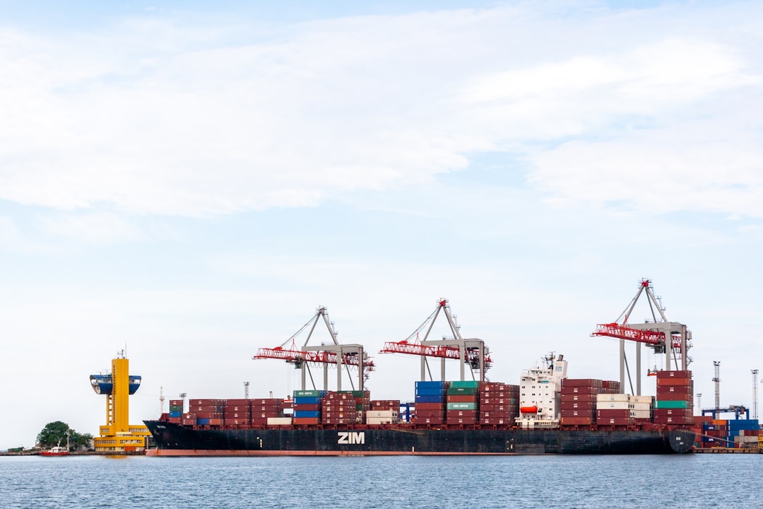 red and blue cargo containers under white clouds during daytime