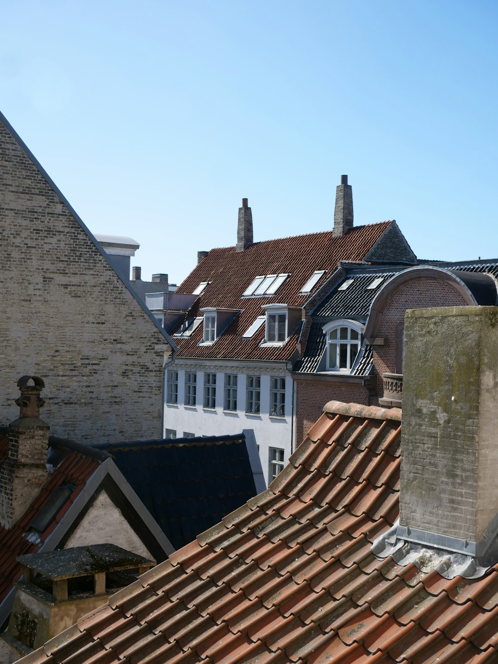 brown brick roof near white and brown concrete house during daytime