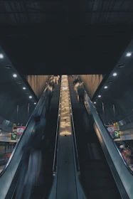 A dynamic escalator in a bustling commercial building with people moving smoothly.