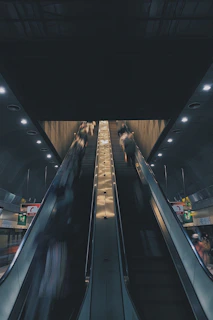 A dynamic escalator in a bustling commercial building with people moving smoothly.