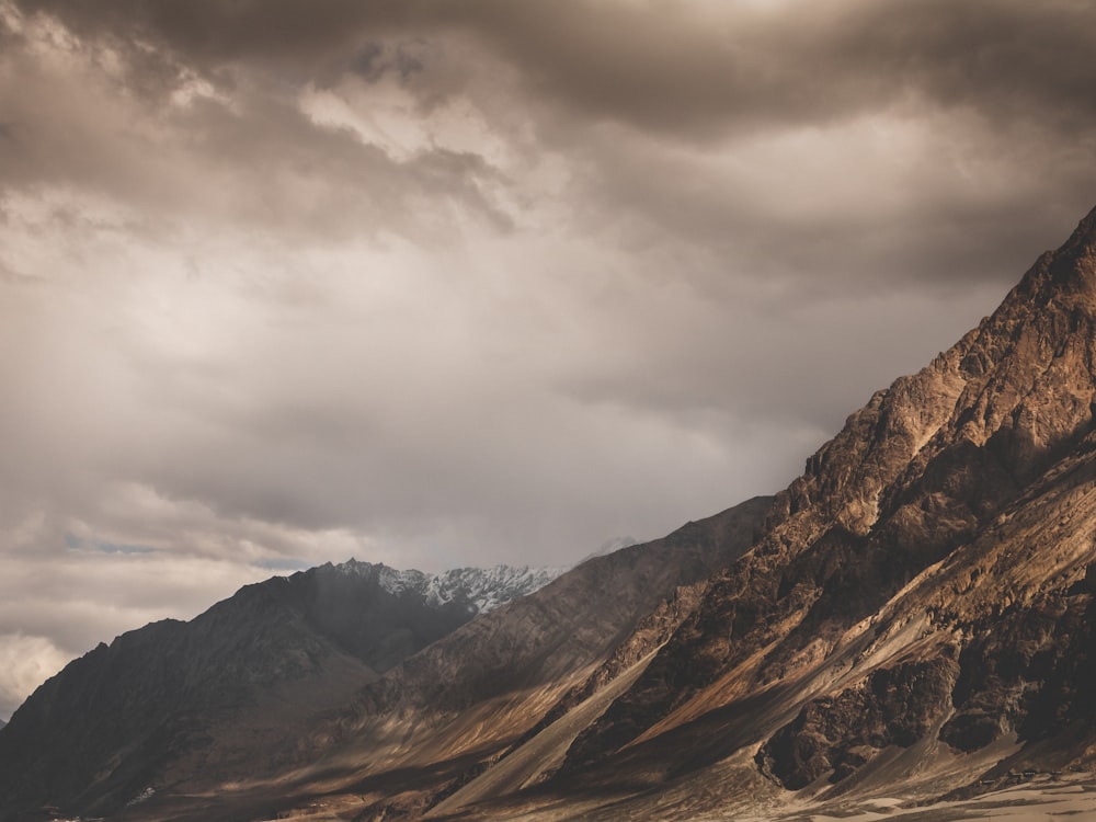 brown and gray mountains under gray clouds