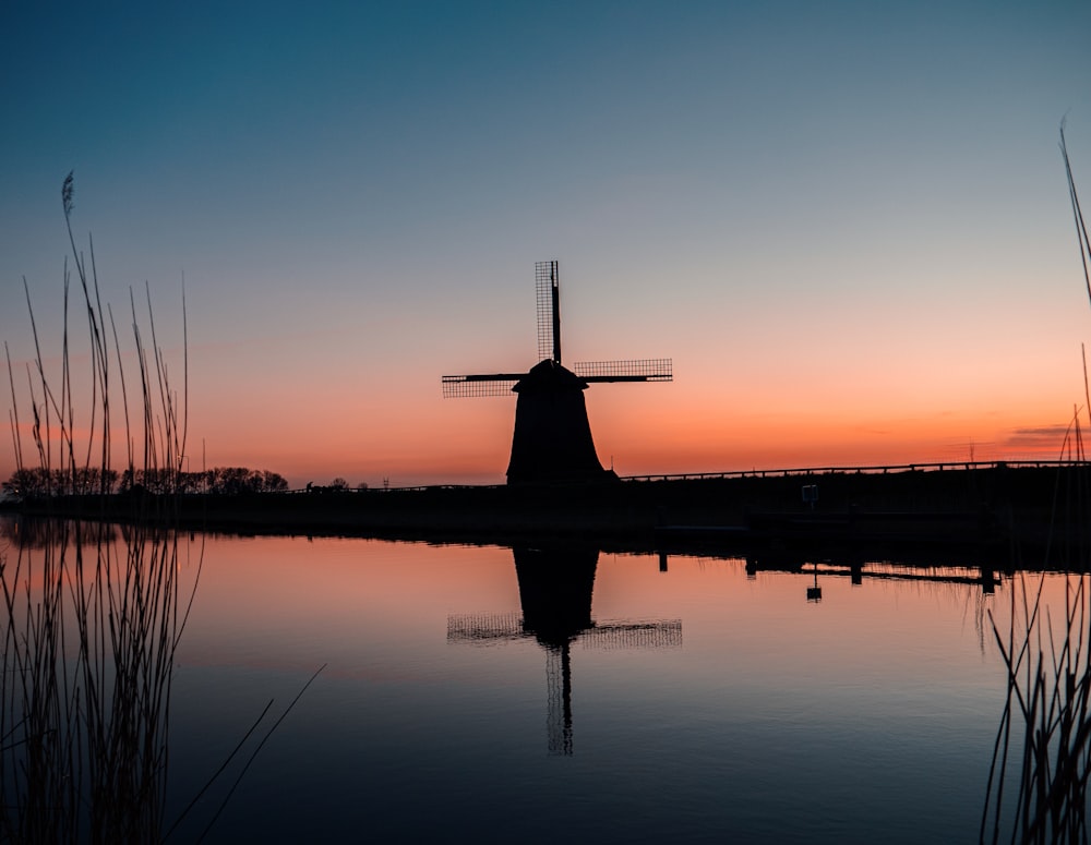 body of water near building during sunset