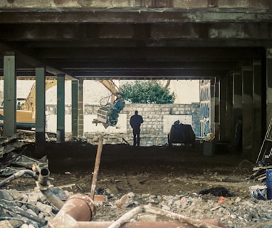 man in black jacket standing near brown wooden post during daytime