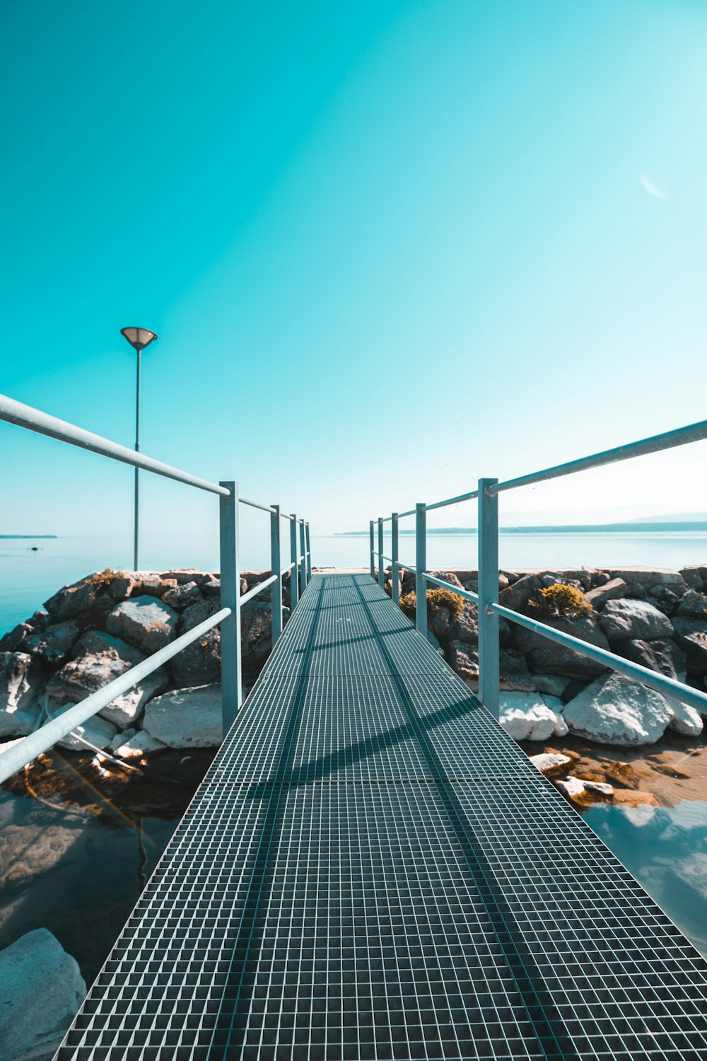 black wooden dock near rocky shore during daytime