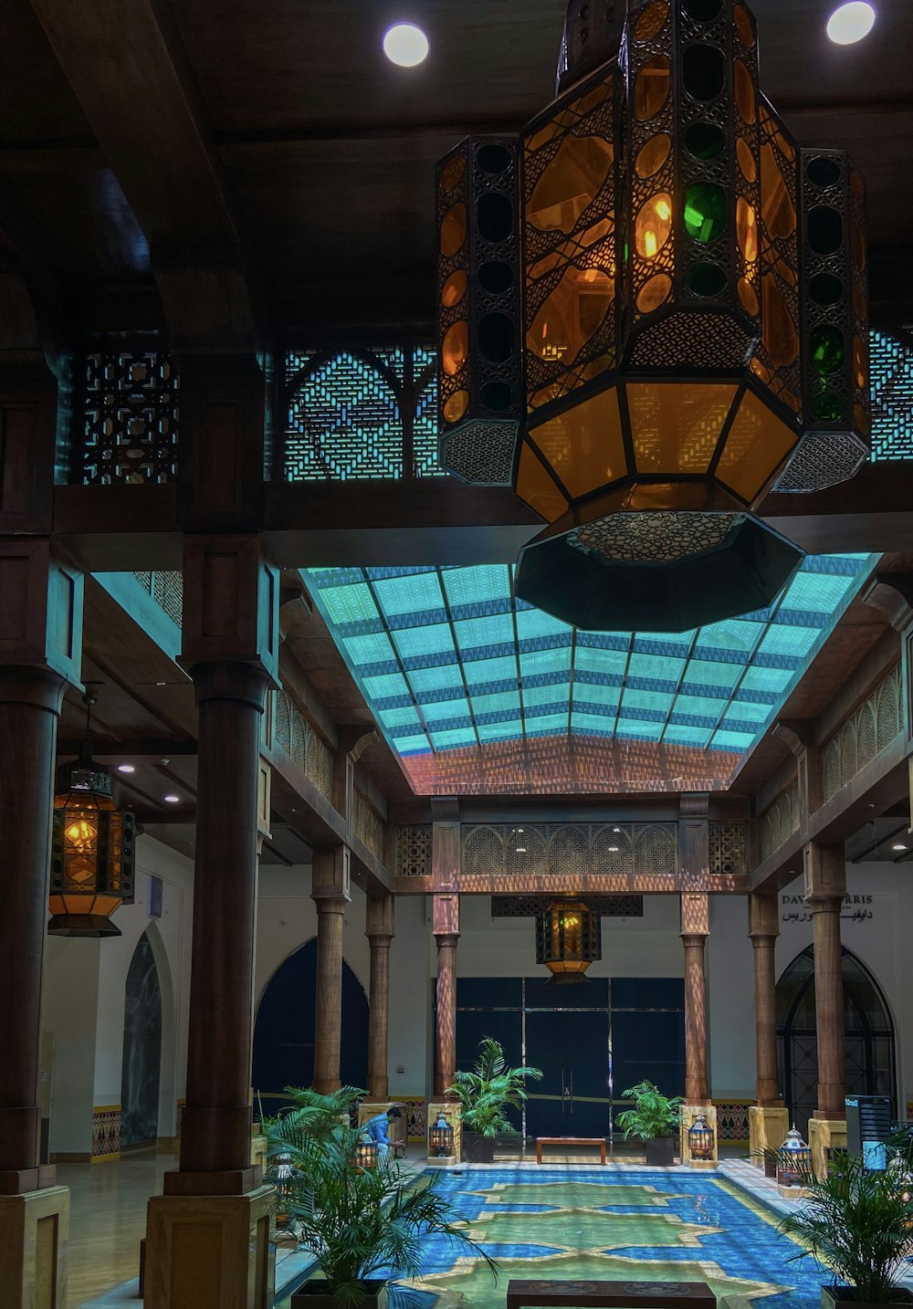 a large room with a blue carpet and a chandelier hanging from the ceiling