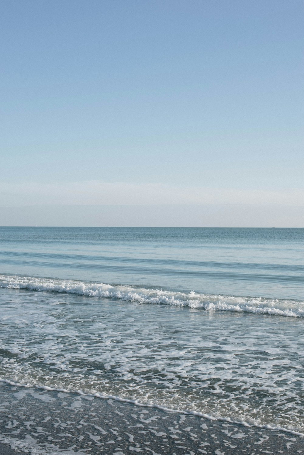 ocean waves crashing on shore during daytime