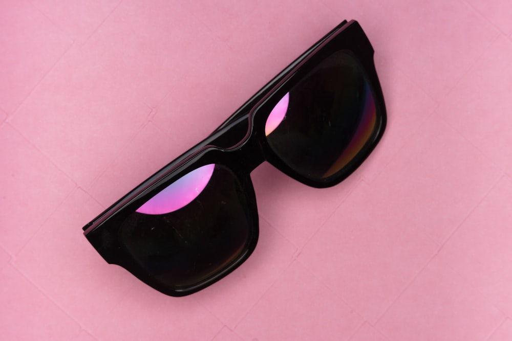 black framed sunglasses on white table