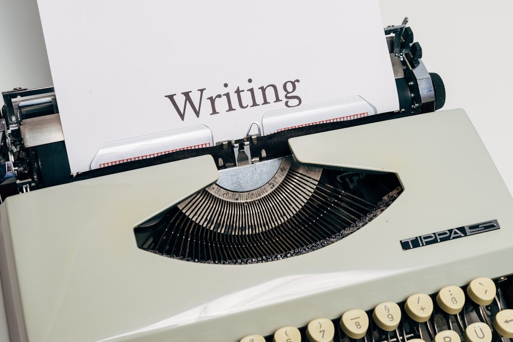 macchina da scrivere in bianco e nero su tavolo bianco