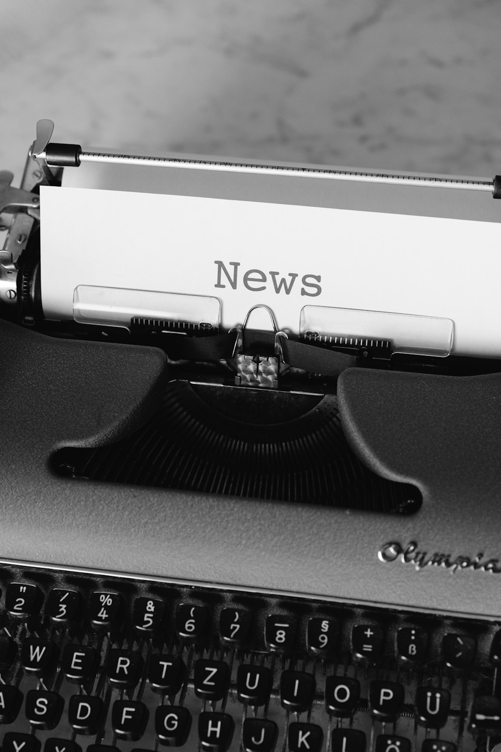 máquina de escribir en blanco y negro sobre mesa negra