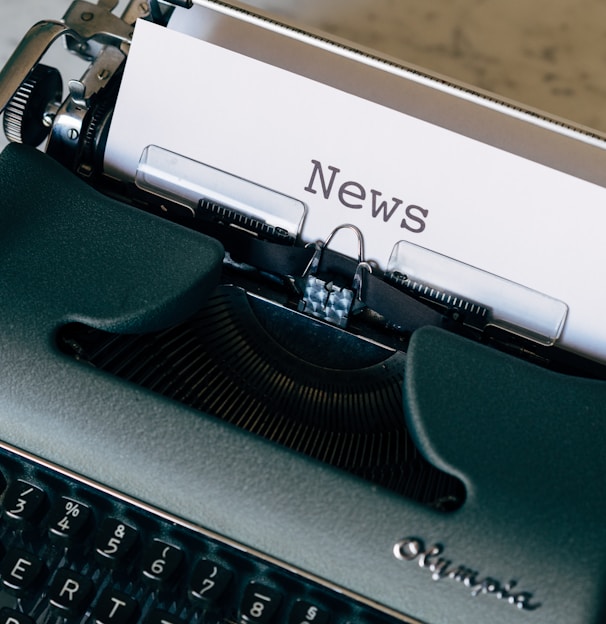 green and white typewriter on brown wooden table