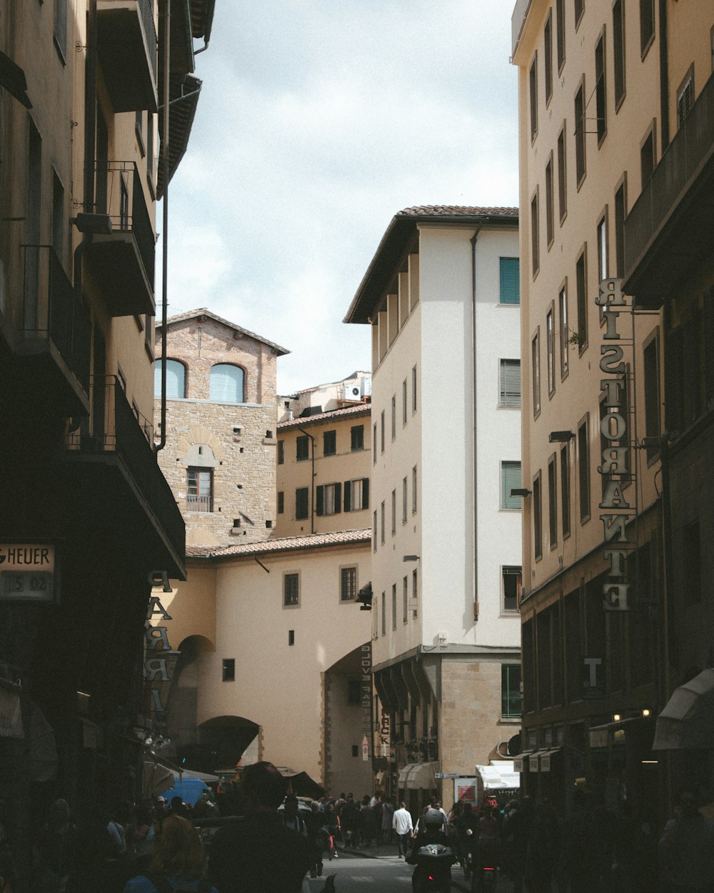 cars parked on side of the road between buildings during daytime