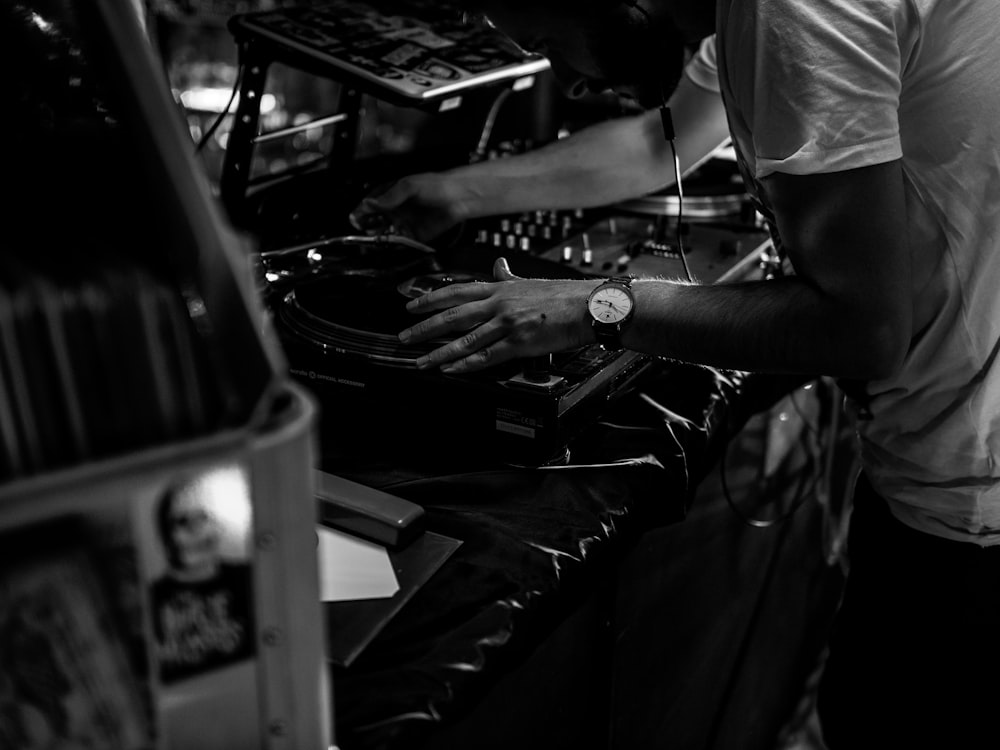 grayscale photo of man in t-shirt playing dj controller