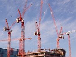 red and white crane under blue sky during daytime