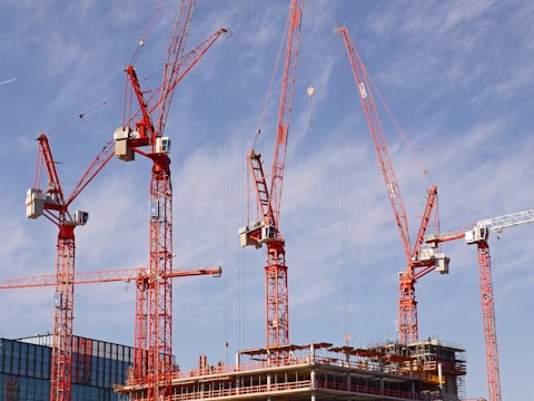 red and white crane under blue sky during daytime
