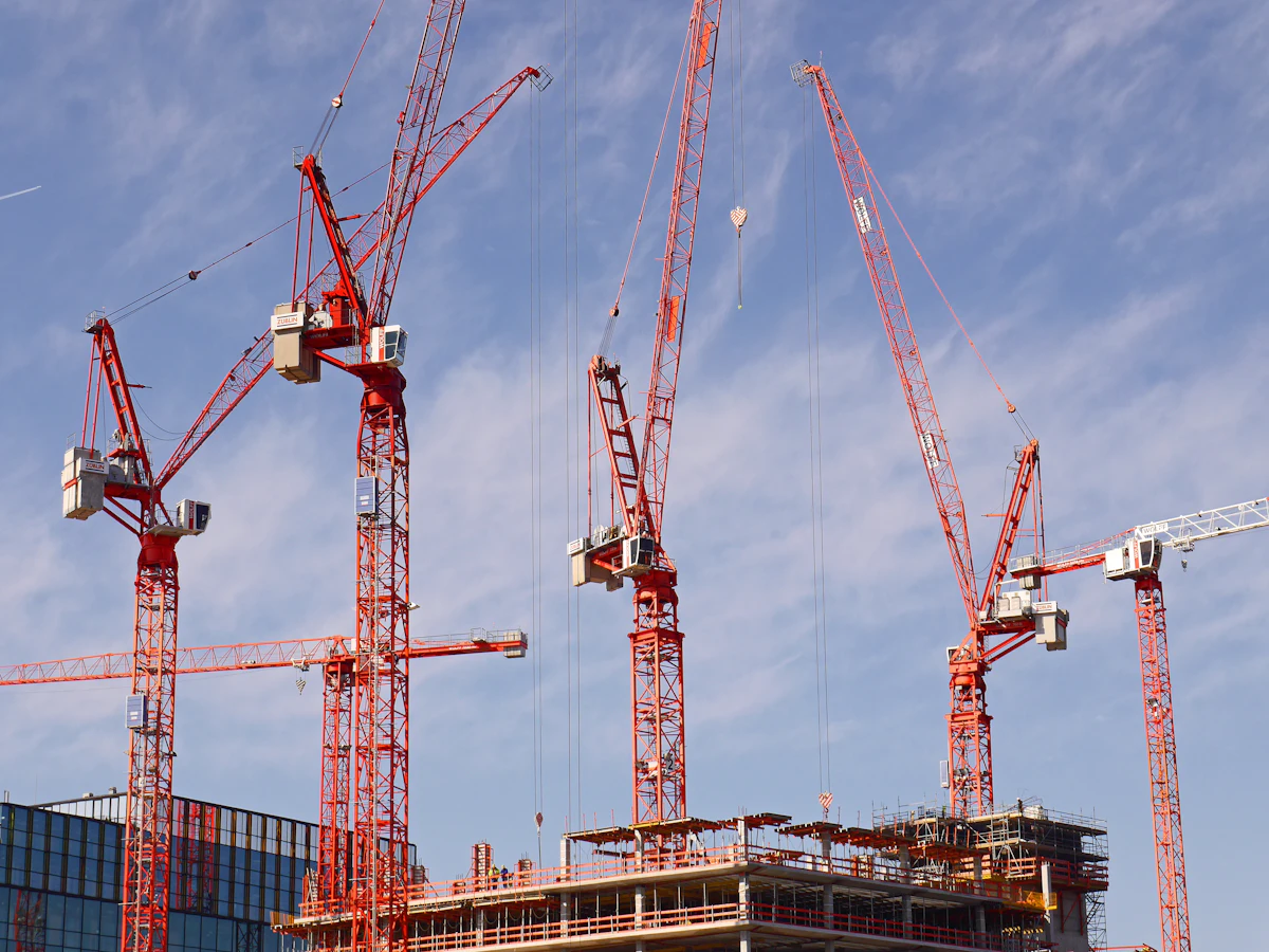 Tower cranes against a blue sky
