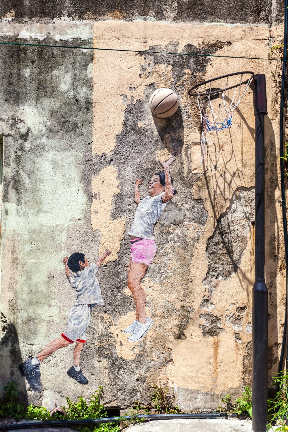 2 boys playing basketball during daytime