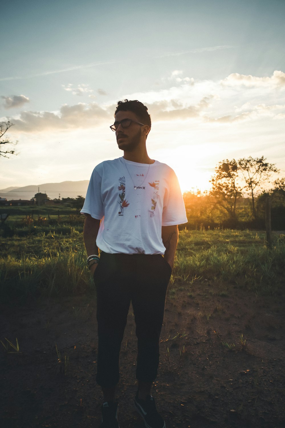 man in white crew neck t-shirt standing on green grass field during daytime