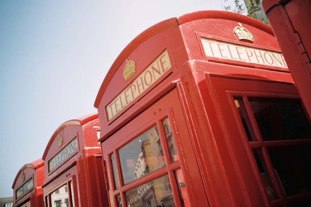 red telephone booth under blue sky during daytime