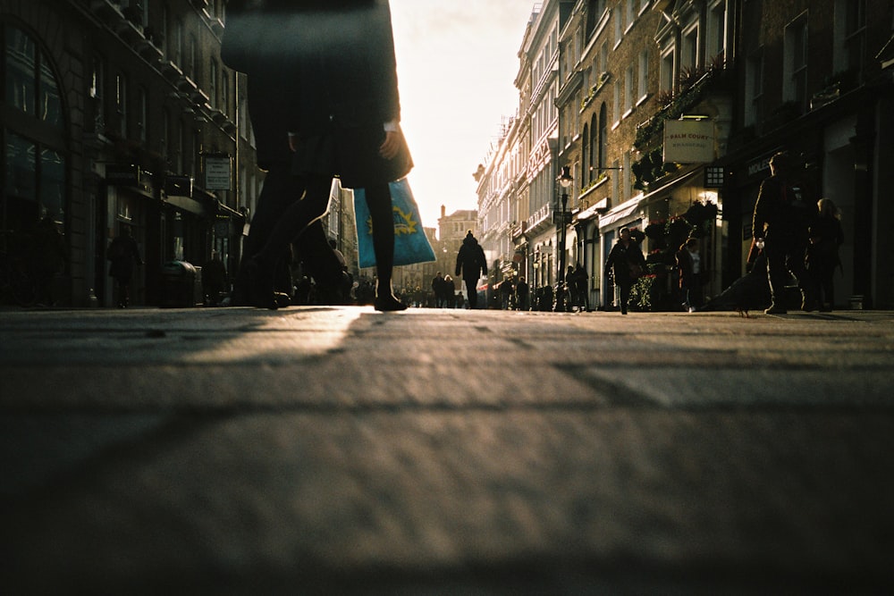 Persona in giacca nera che cammina per strada durante il giorno