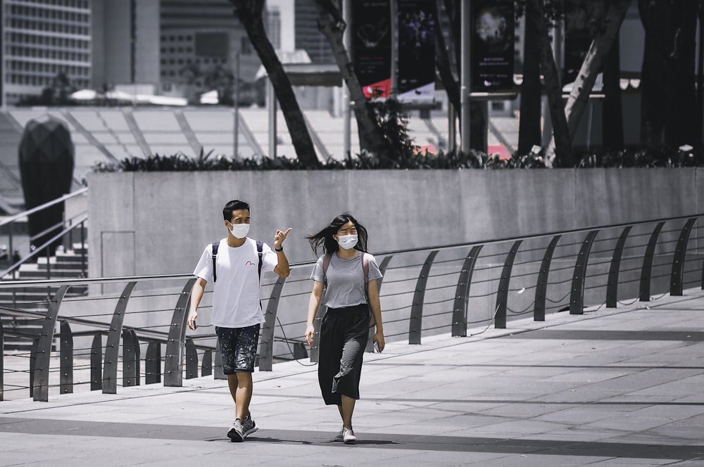 man and woman standing on gray concrete floor during daytime