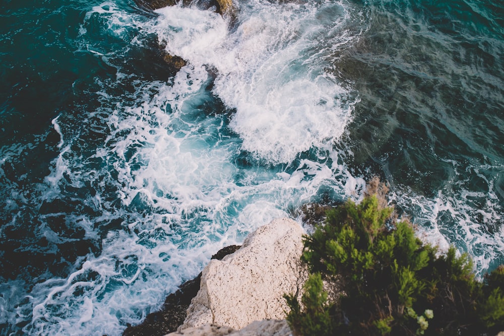 brown rocky shore with water waves during daytime