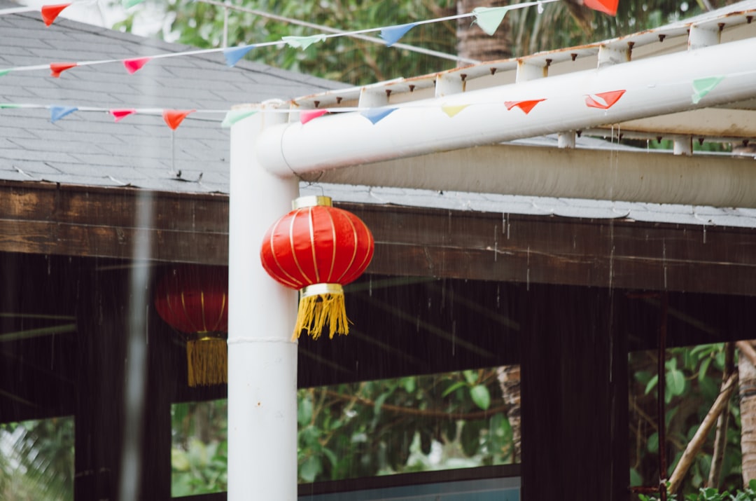 orange and yellow paper lantern hanged on white metal pole