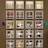 A wall display features various bottles of wine organized into individual illuminated cubbyholes. Each section has a handwritten label indicating categories such as Chardonnay, Bubbles, and Napa. Decorative elements include small paper ornaments.