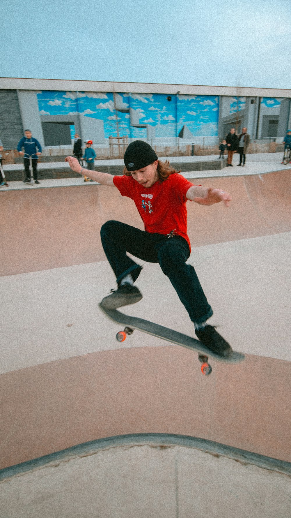 man in red shirt and black pants riding skateboard