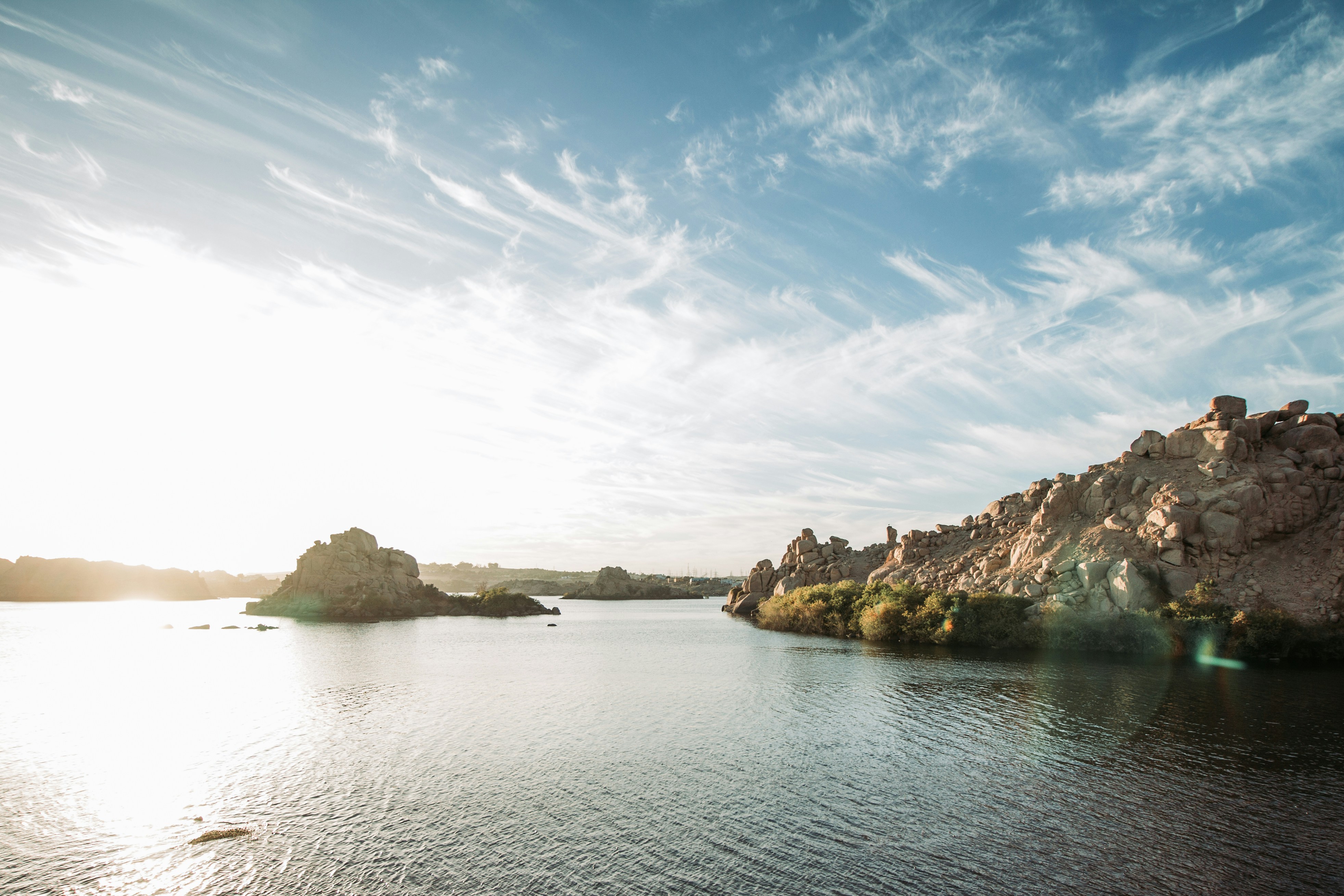 brown rock formation on body of water under blue sky during daytime
