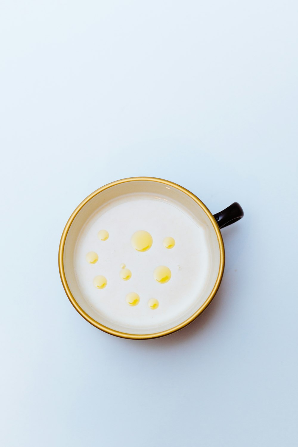 white liquid in black and yellow ceramic mug