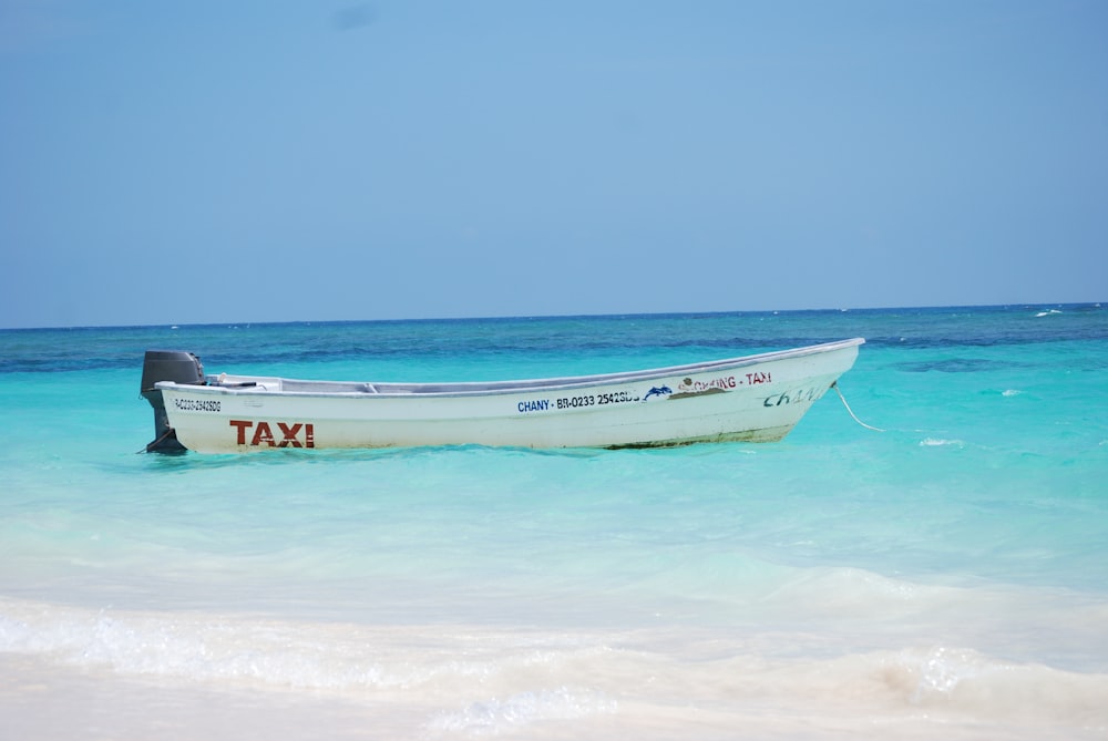 white and blue boat on sea during daytime