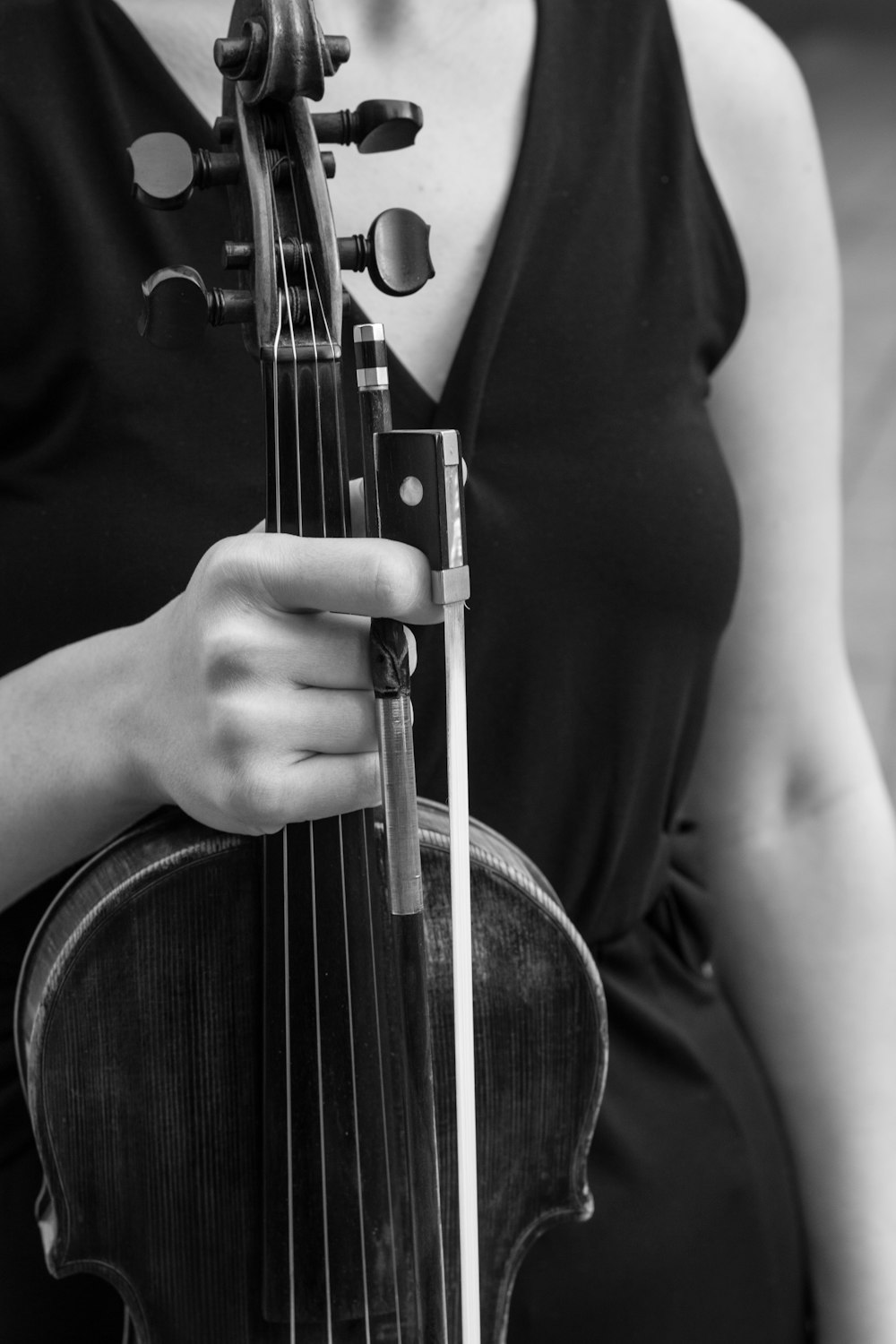 person playing violin in grayscale photography