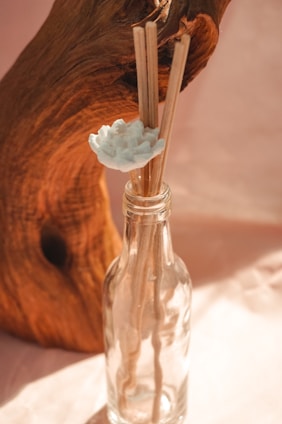 Artisanal glass bottles with colorful botanicals inside, surrounded by soft natural light and rustic wooden textures.