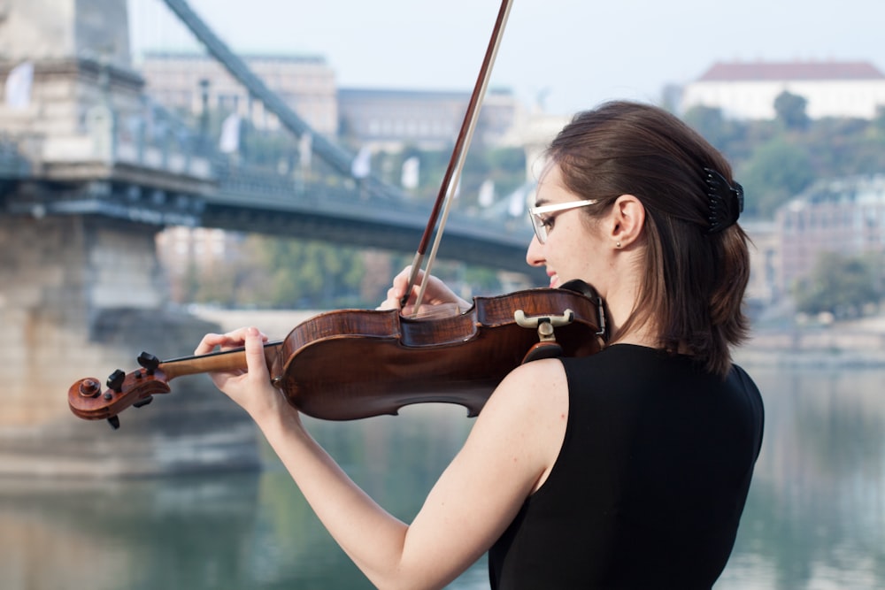 woman in black tank top playing violin