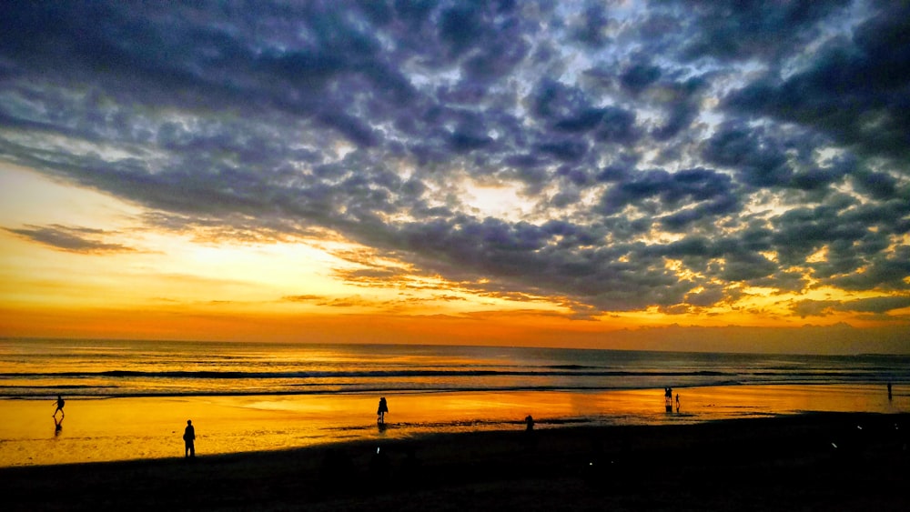 silhouette of people on beach during sunset