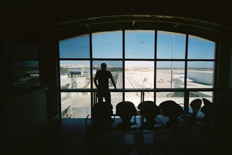 silhouette of man standing near glass window