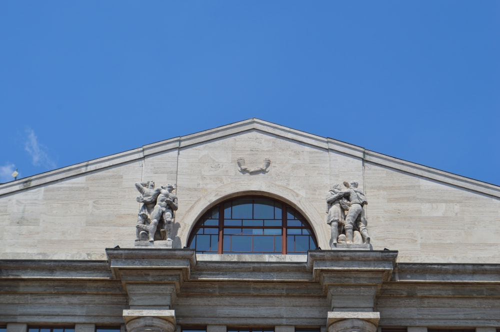 edificio in cemento bianco sotto il cielo blu durante il giorno