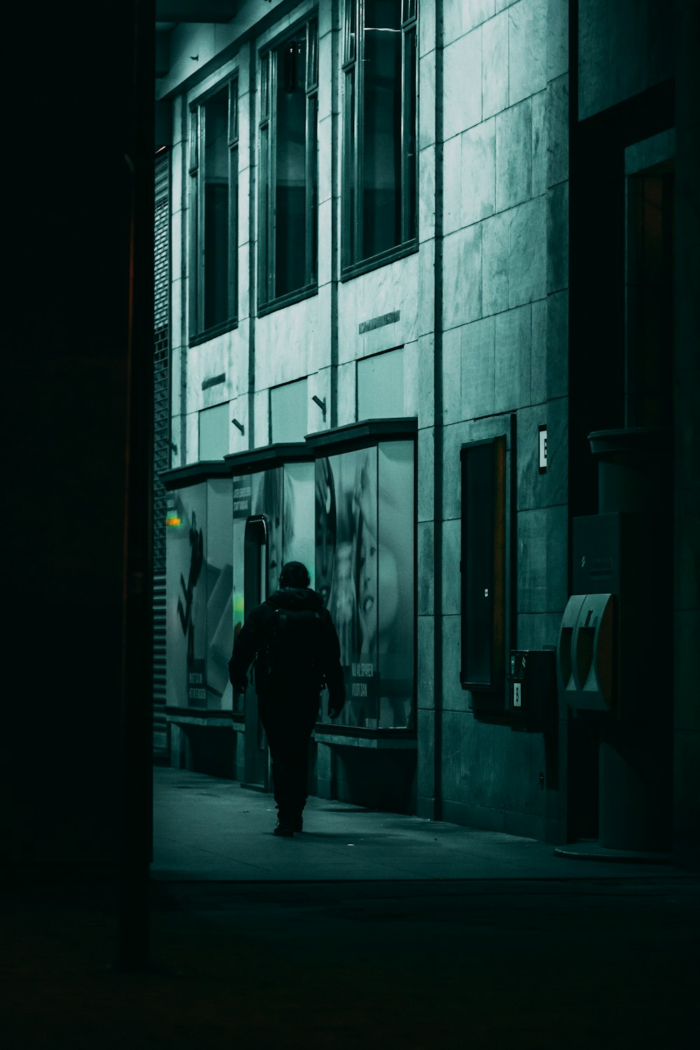 man in black jacket walking on hallway