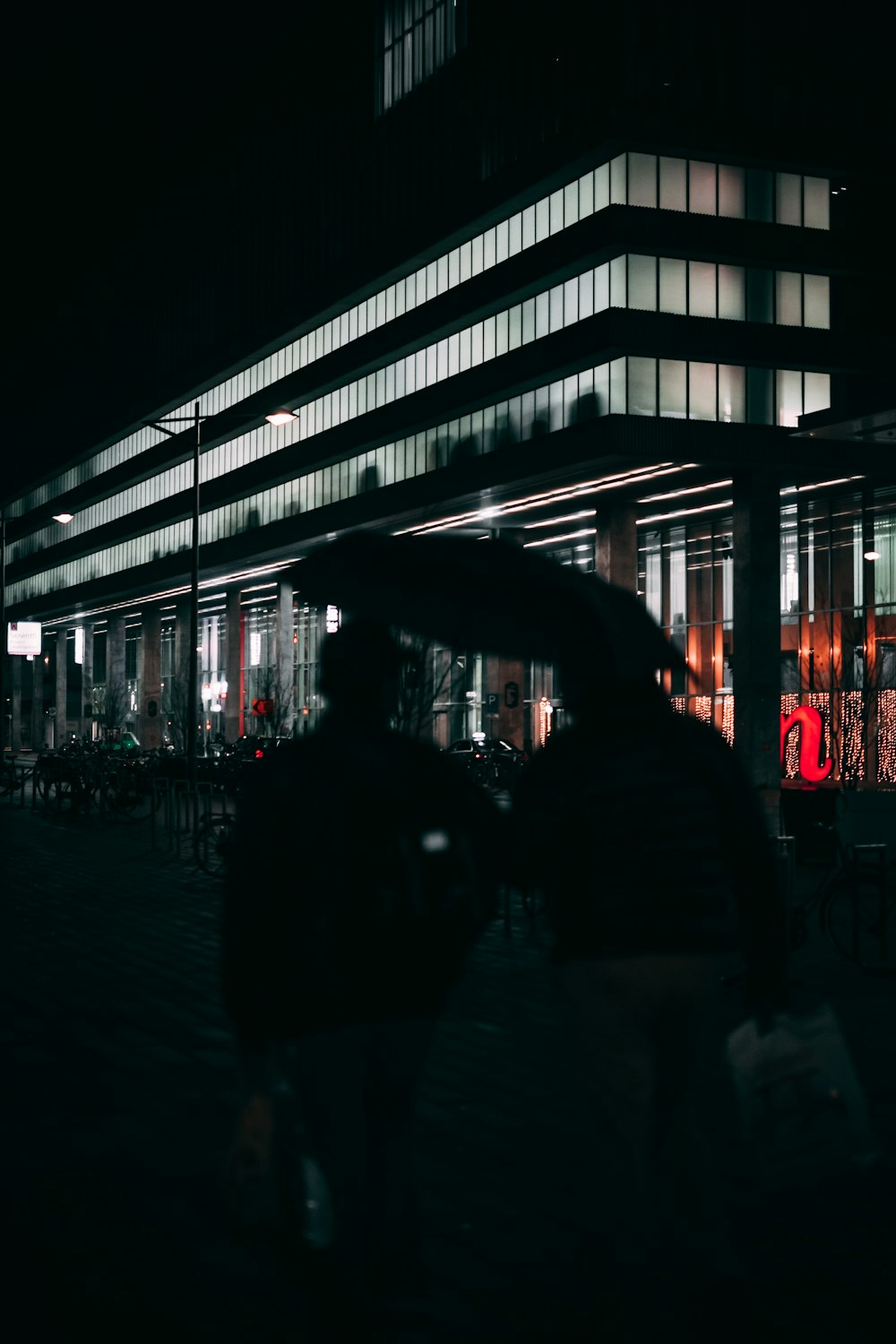 people walking on sidewalk during night time