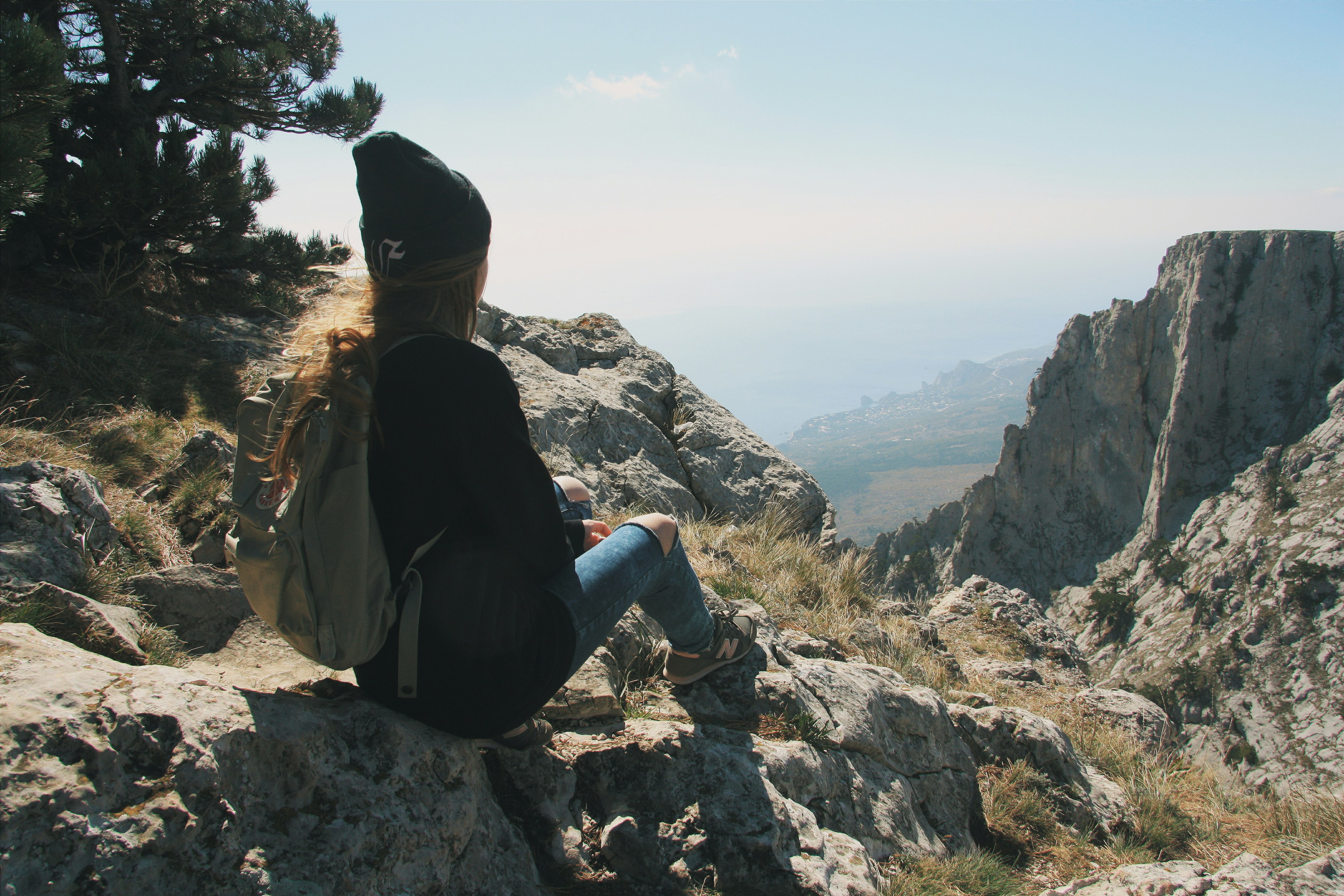 girl sitting on a rock and looking at the black sea